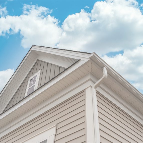 view of soffit and fascia isntallation from below against blue sky with clouds